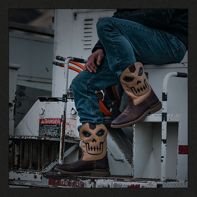 A cowboy sitting on a boat wearing the Syphon western boot in tan.
